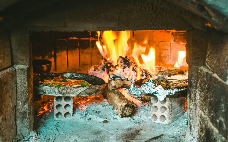 Houtvuur met hoge vlammen in een stenen oven